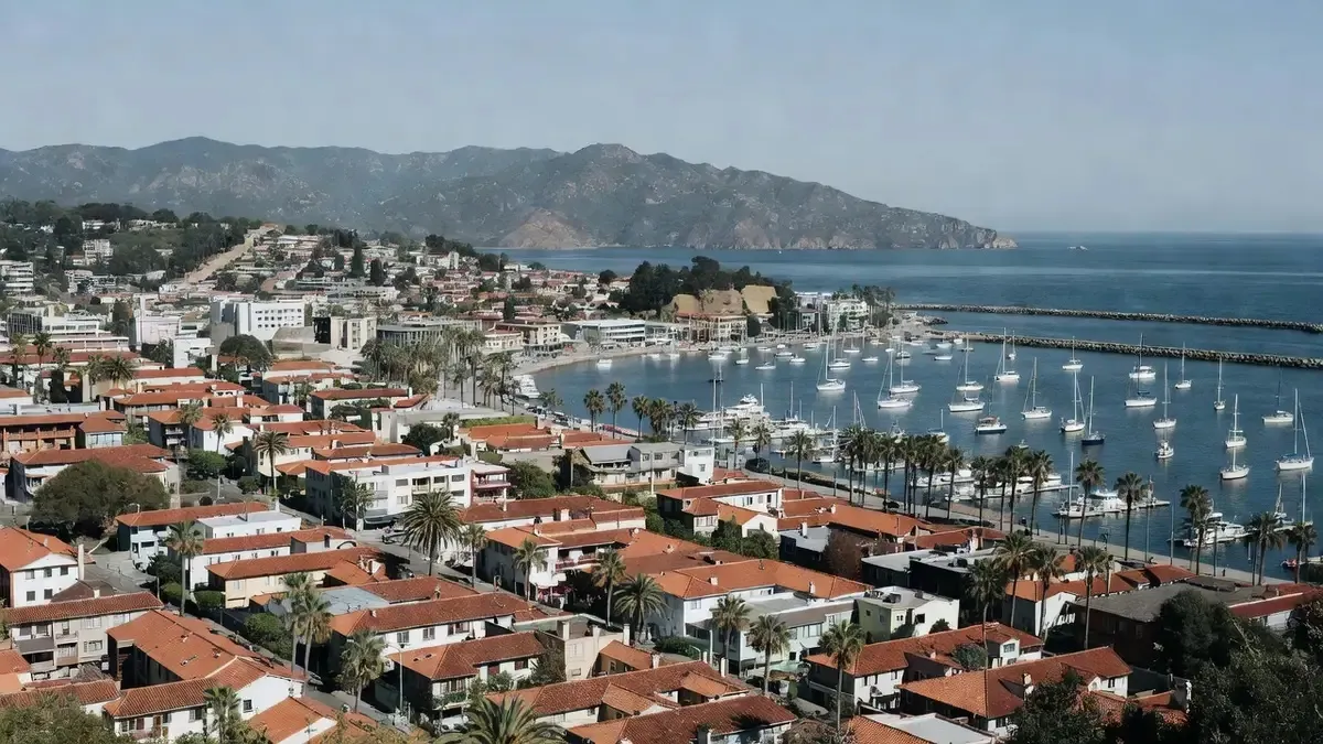 Private helicopter banking over downtown Santa Barbara with the harbor, Spanish Colonial rooftops, and the Santa Ynez Mountains visible on a santa barbara helicopter tour